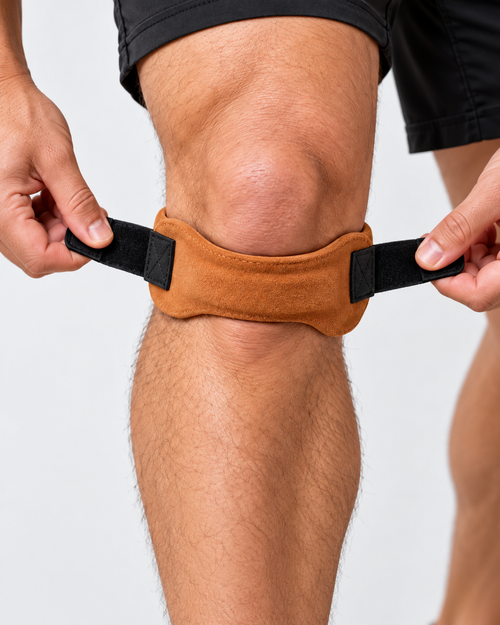STEP STRG tan cowhide patella knee support strap being worn below the kneecap